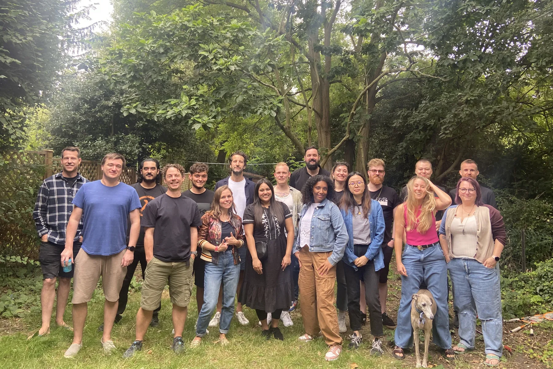 The Measurelab team in a garden in summer 2023, with a dog at the front