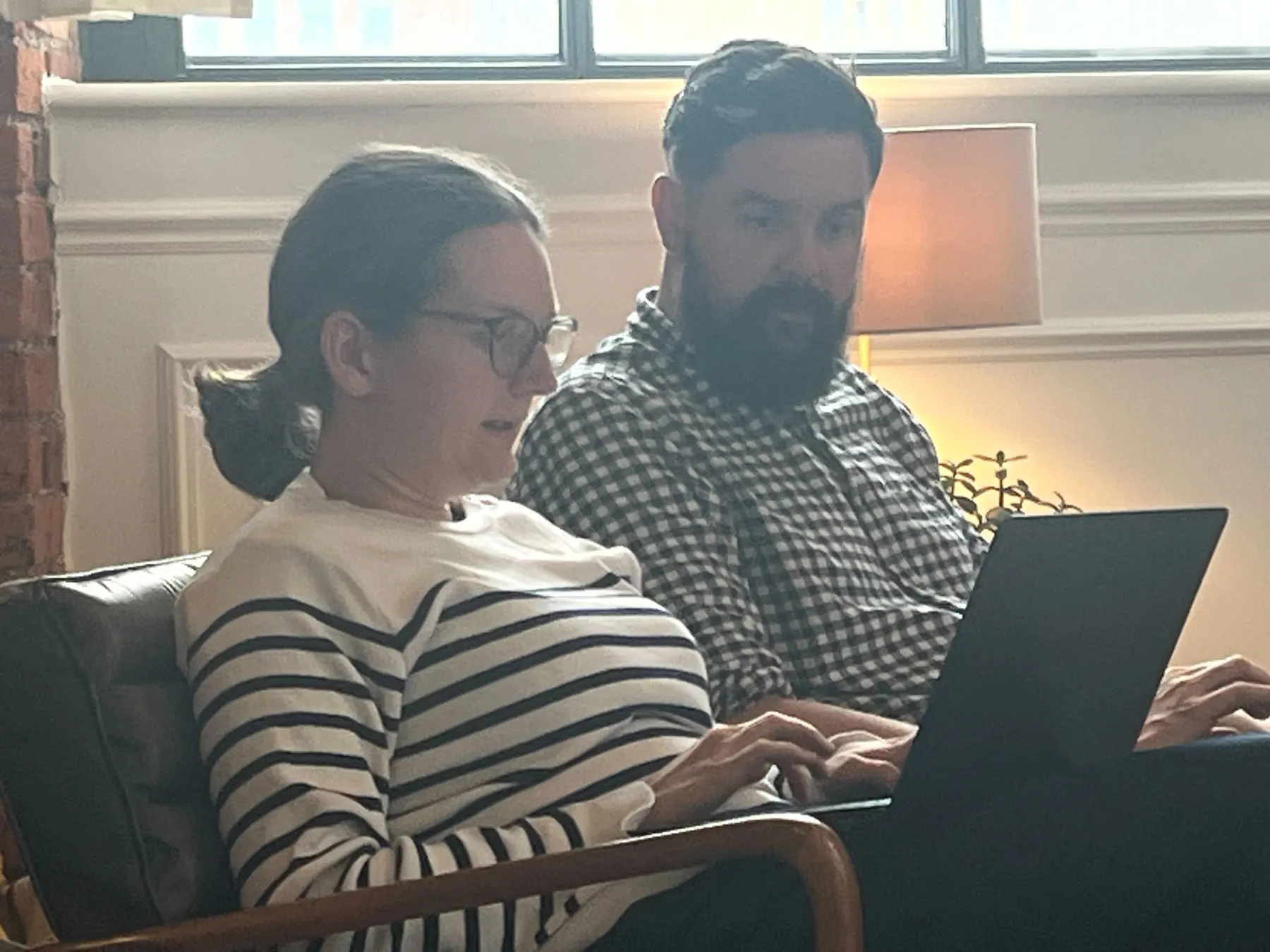 Two colleagues working through something together on a laptop