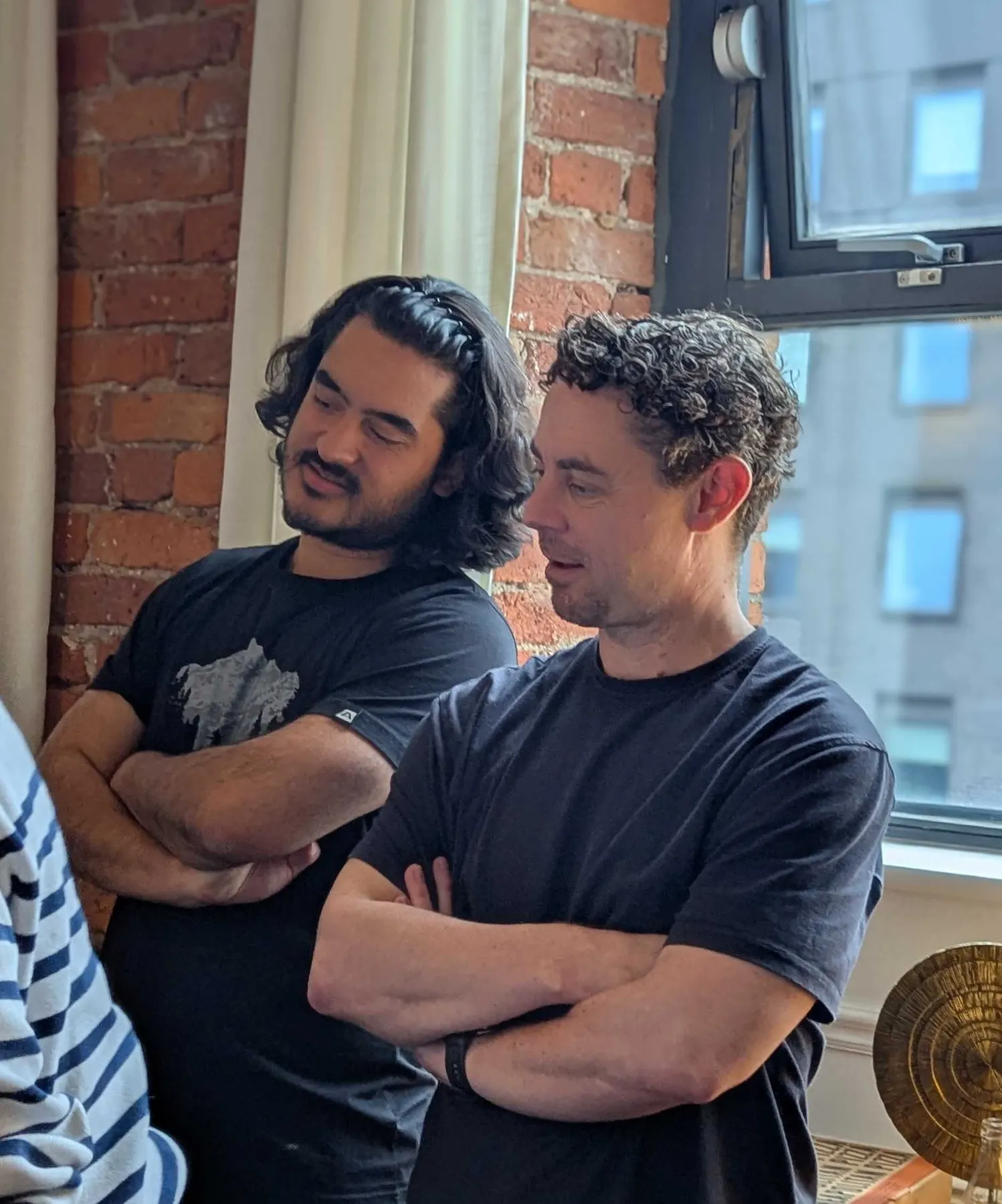 Two colleagues listening during a team session by a window