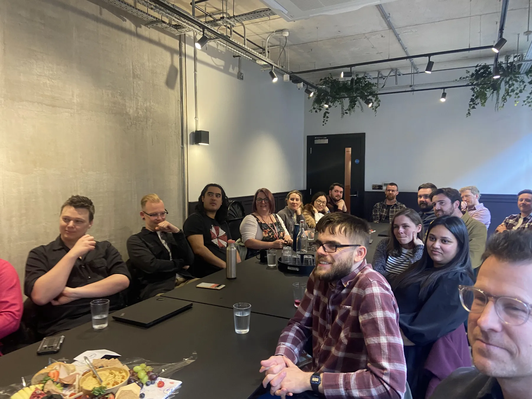 The team round a long table in the Manchester meeting room, listening to a presentation