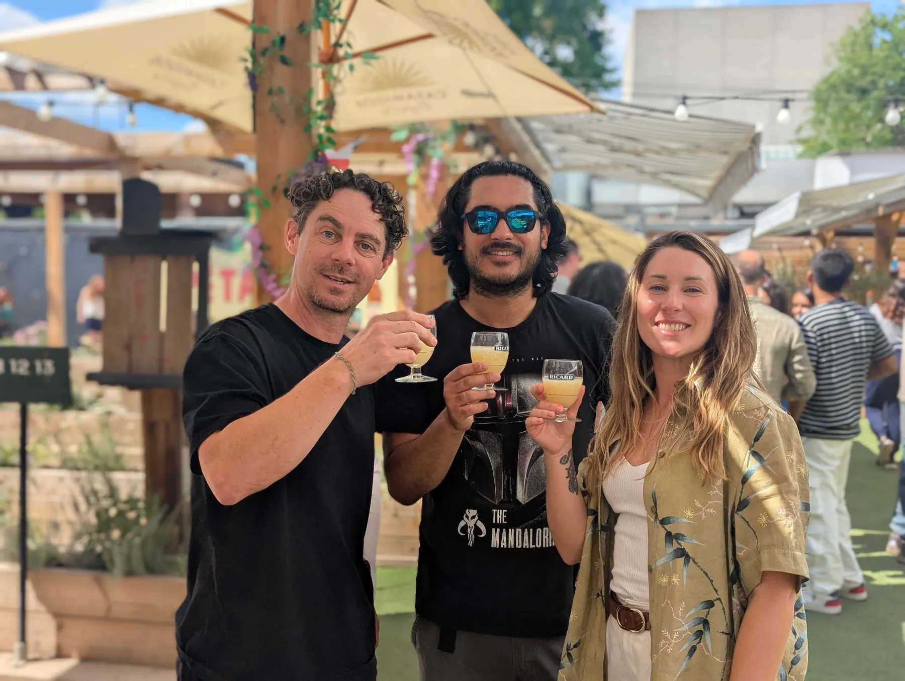 Three colleagues raising a glass at the summer social